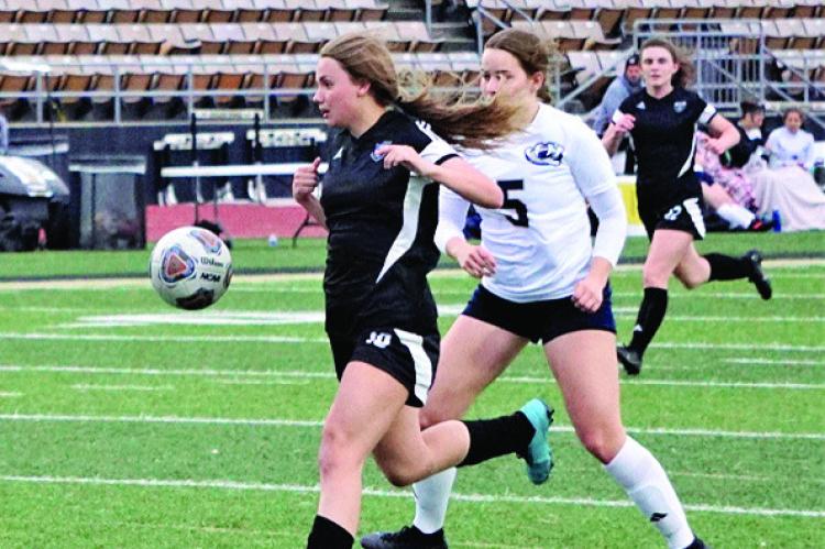EXCELSIOR SPRINGS junior Abby Rash shields the ball and races past a William Chrisman defender en route to scoring a goal during the Tigers’ 4-2 March 30 home loss. DUSTIN DANNER | Staff