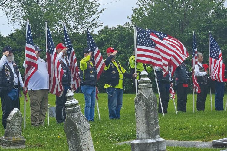 MILITARY VETERANS hold American Flags and salute in honor of their fellow soldier Cpl. Charles Ryan Patten, who died in the Korean War. MIRANDA JAMISON | Staff